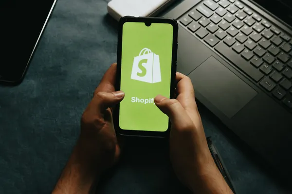 Mann nutzt Shopify auf dem Smartphone